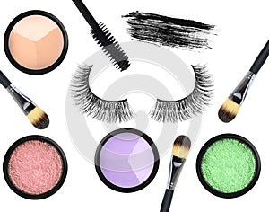 Black false eyelash, mascara, eyeshadows and brushes isolated on