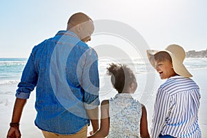 Black family, beach and walking during summer on vacation or happy holiday laughing and enjoying the scenery at the