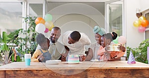 Black family, birthday and present for children together for bonding, love and celebration. African woman, men and happy