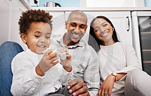 Black family, children and a boy playing with a toy car while his parents smile, sitting on the kitchen floor. Kids