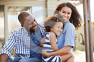 Black family embracing outdoors smiling to camera outside photo