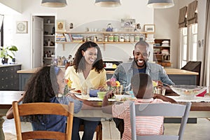 Black family of four having lunch in their kitchen at home