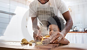 Black family having fun prepare bakery together at home. African American father and adorable son kneading dough in kitchen. Happy