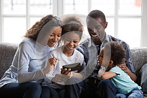 Black family and kids laughing watching funny video on phone