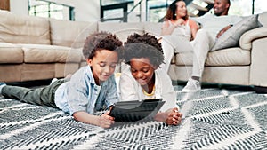 Black family, kids and siblings on a floor with tablet, search or streaming, cartoon or games at home together. Digital