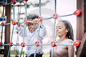 Black family mother and son enjoying time together at the playground park having fun.
