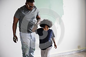 Black family painting house wall together