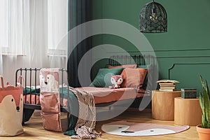 Black fancy chandelier in fashionable teenager bedroom with single bed