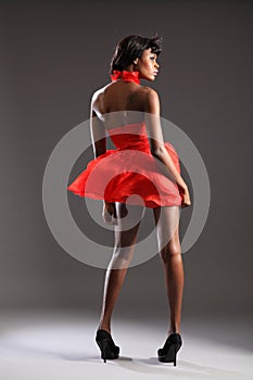 black fashion model in red dress and heels