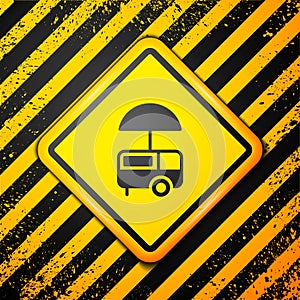 Black Fast street food cart with awning icon isolated on yellow background. Urban kiosk. Ice cream truck. Warning sign