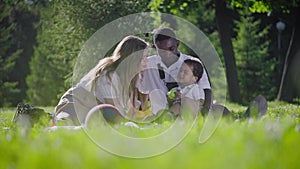 Black father, fair-skinned mother and mestizo child in the park. Happy family on a picnic in the park. Joyful