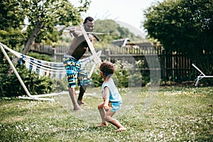 Black father playing with his son outside on a summers day