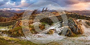 Black Fell panorama looking towards Lake District mountains covered in snow.