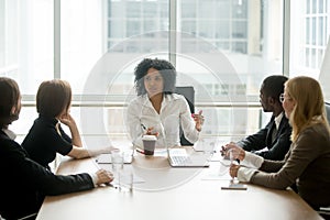 Black female boss leading corporate meeting talking to diverse b photo