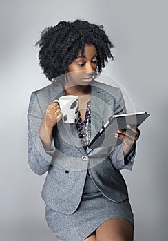 Black Female Businesswoman Keynote Speaker Posing with a Tablet and Coffee photo