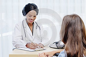 Black female doctor consulting with European patient about her health in hospital. medical operation