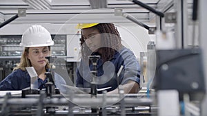 Black female factory engineer teaching middle aged employee