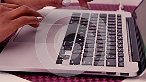 Black female hands typing on laptop computer keyboard. Woman uses laptop for remote work, social networking or distance