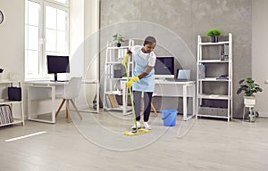 Black female janitor clean floor in office space