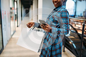 Black female person with phone and shopping bags