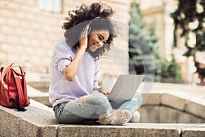 Black Female Student Using Laptop Having Online Lecture Sitting Outdoors