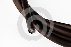 black fiber optic cable for internet connection on a white background close-up.