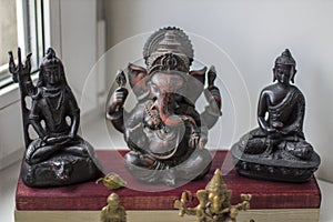 Black figurines of Shiva, Ganesha Buddha on the windowsill