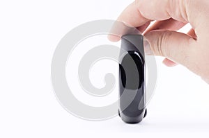 Black fitness bracelet in a female hand isolated on a white background. The concept of modern gadgets for sports and healthcare.
