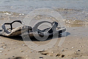 black flip flops on the beach, summer vacations