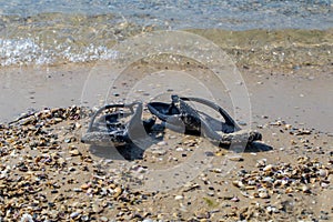 black flip flops on the beach, summer vacations