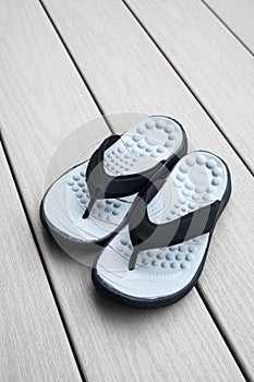 Black Flip Flops on Gray Deck Background