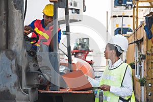 Black foreman worker driving forklift checking at Container cargo harbor to loading containers. African dock female staff using