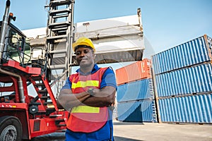 Black foreman worker working control the crane and forklift at Container cargo harbor to loading containers. African dock male