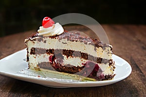 Black Forest cake with chocolate and cherry brandy on a wooden t