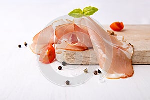 Black forest ham and basil on wooden cutting board