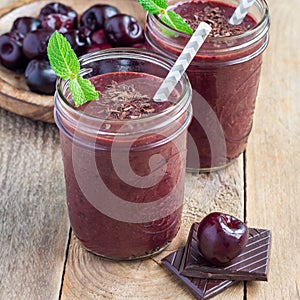 Black forest smoothie with cherry, almond milk and cacao powder in glass jar, square format