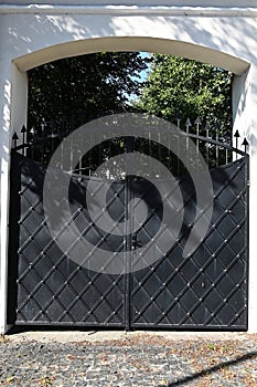 black forged gates closing the entrance to private property