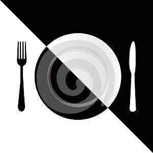 Black fork, white knife and half black and half white plate