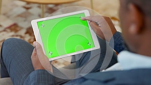 Black formal businessman using digital tablet with green screen