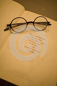 Black frame glasses are placed on the Chinese-English Bible photo