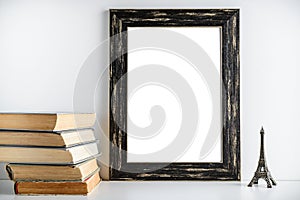 Black frame layout. Toy tower and old books near the frame on a