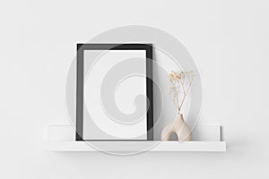 Black frame mockup with a gypsophila decoration on the wall shelf