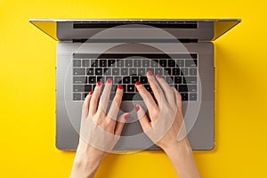 Black friday concept. First person top view photo of female hands typing on laptop keyboard on isolated yellow background