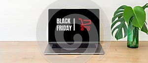 Black friday concept. Laptop computer screen with shopping card and sign