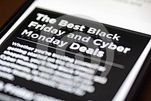 Black Friday and Cyber Monday Deals text on shopping app on smartphone screen closeup