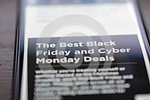 Black Friday and Cyber Monday Deals text on shopping app on smartphone screen closeup