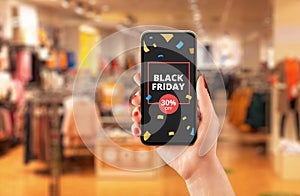 Black friday discount advert on smart phone in woman hand