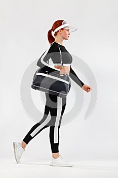 Black friday for fitness sale. Sporty fit woman with bag go to training, running on white background. Dynamic movement