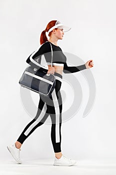 Black friday for fitness sale. Sporty fit woman with bag go to training, running on white background. Dynamic movement