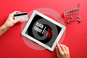 Black friday online shopping concept. Hand with debit card, tablet with